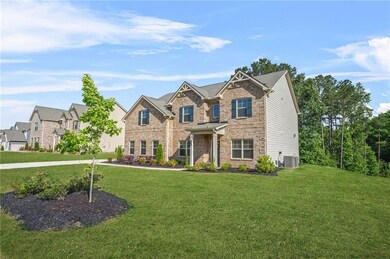 Craftsman house with cooling unit, a front yard, and brick siding