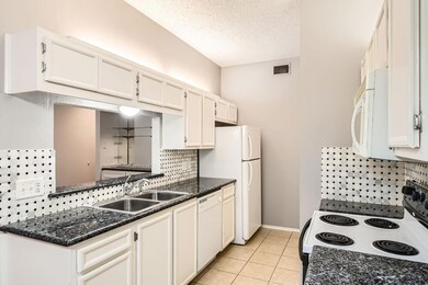 Kitchen featuring a sink, backsplash, white appli