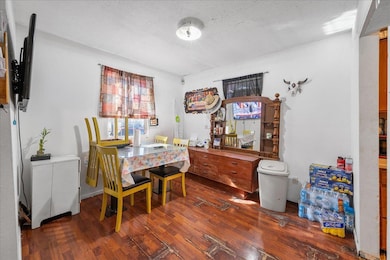 Dining area featuring a textured ceiling and wood finished floors