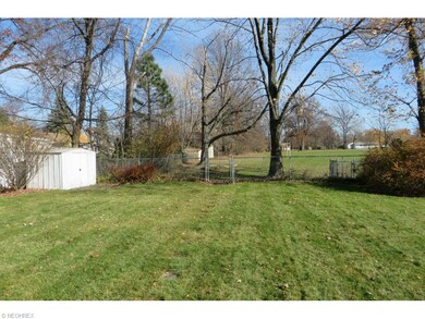 Storage shed for garden equipment and view of back yard that backs up to a school.