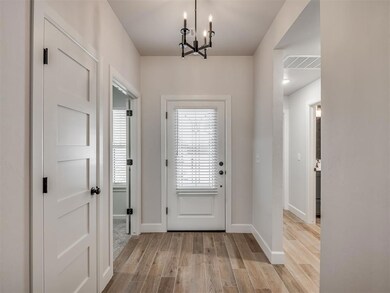 Doorway featuring a chandelier and wood finished floors