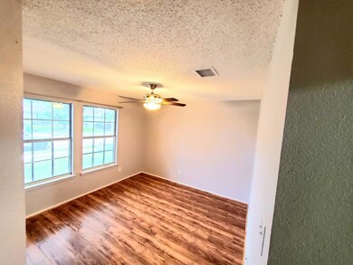Spare room featuring ceiling fan, hardwood / wood-style flooring, and a textured ceiling