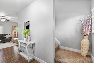 Staircase featuring plenty of natural light, ceiling fan, and wood finished floors