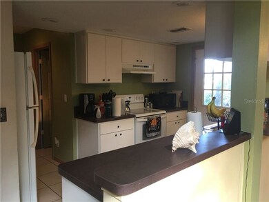 Kitchen over bar with side door and hallway to gar