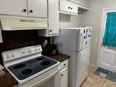 Kitchen featuring white appliances, light tile pat
