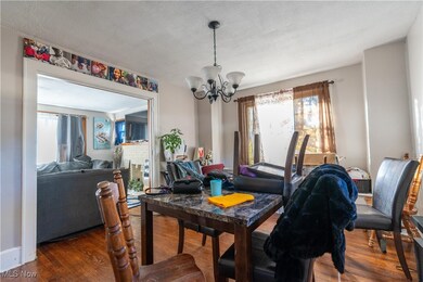 Dining room with hardwood floors, a chandelier, and a textured ceiling.