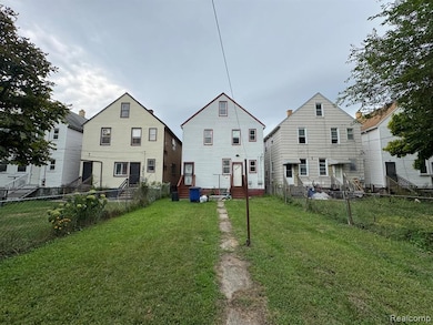 Rear view of house with a fenced backyard and entry steps