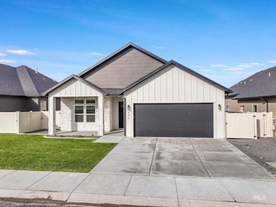 Modern inspired farmhouse featuring a gate, board and batten siding, an attached garage, and driveway