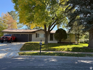 Ranch-style house with concrete driveway, a front lawn, and a garage