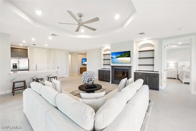 Tiled living room featuring a tray ceiling, built