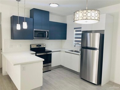 Kitchen featuring stainless steel appliances, a peninsula, backsplash, light countertops, and pendant lighting