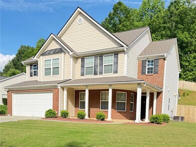 View of front facade featuring driveway, a garage, brick siding, covered porch, and roof with shingles