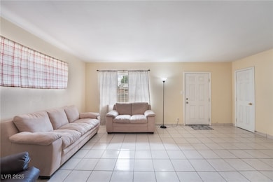 Living area featuring light tile patterned flooring and baseboards