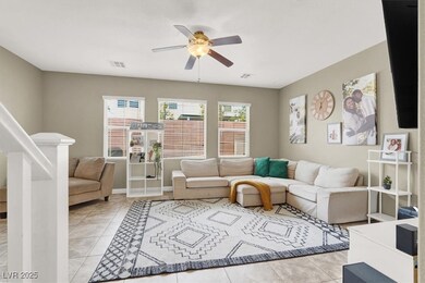 Living area with ceiling fan and light tile patter