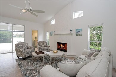 Living room featuring a stone fireplace, ceiling f