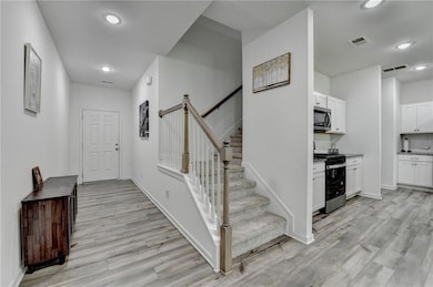 Stairs with wood finished floors, recessed lightin