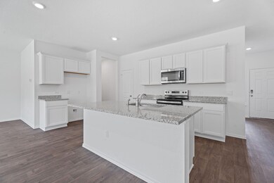 Kitchen with white cabinetry, stainless steel app