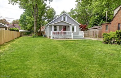 Rear view of house featuring a wooden deck and a yard