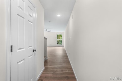 Corridor with dark wood-style floors and recessed lighting