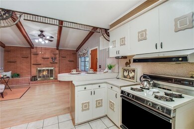 Large kitchen with breakfast bar is open to hearth