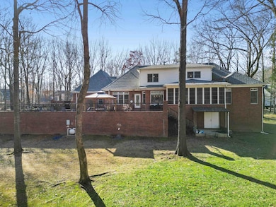 Back of property with a lawn, a wooden deck, and a