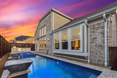 Pool at dusk featuring an in ground hot tub