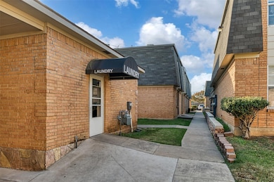 View of side of property with roof with shingles, brick siding, and mansard roof