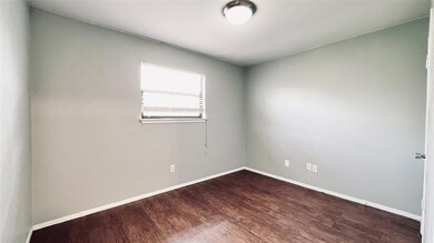 Spare room with baseboards and dark wood-type flo