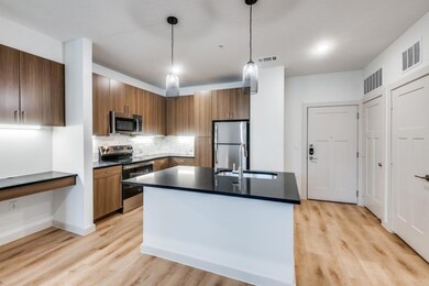 Kitchen with dark countertops, visible vents, appl