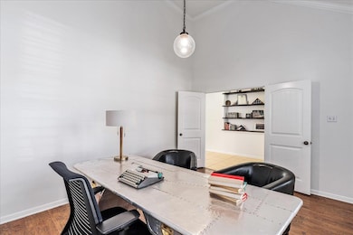 Home office featuring ornamental molding, high vaulted ceiling, and dark wood flooring