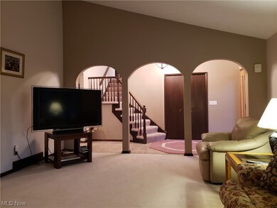 Living room featuring lofted ceiling and light colored carpet