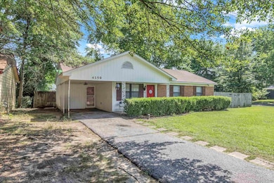 View of front of house with driveway and an attached carport