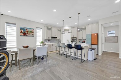 Kitchen featuring a breakfast bar, a center island with sink, healthy amount of natural light, freestanding refrigerator, and recessed lighting