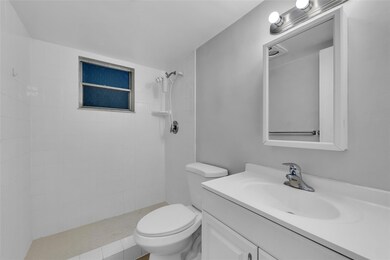 Bathroom offers a walk in shower and white vanity
