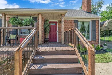 The new porch railing, bright red door, and fresh landscaping give this home excellent curb appeal