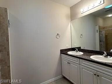 Full bath featuring a sink, baseboards, double van