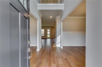 Foyer featuring baseboards, crown molding, wainsco