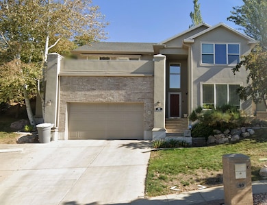 View of front of home featuring stucco siding, brick siding, and concrete driveway