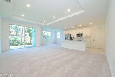 Living room featuring gray carpet and a tray ceiling