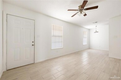 Spare room with ceiling fan, light wood-type flooring, and baseboards