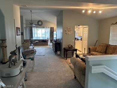 Living room featuring lofted ceiling, ceiling fan,