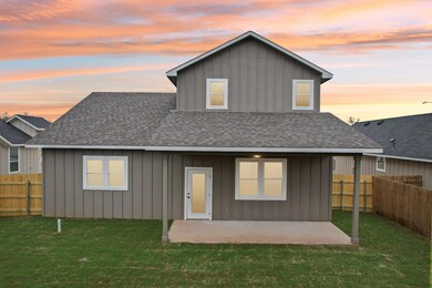 Back of property at dusk with a patio, roof with 