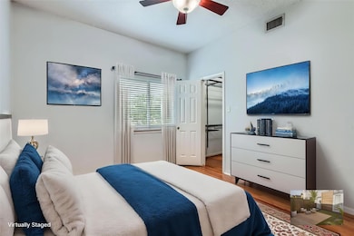 Bedroom with wood finished floors, a spacious clo