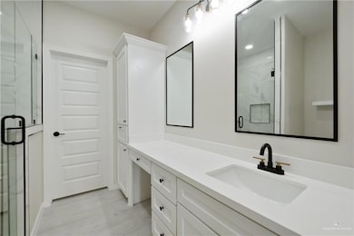 Full bath featuring a marble finish shower and vanity