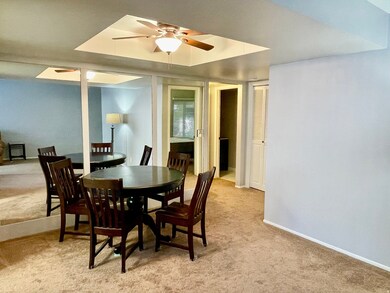 Dining space featuring light carpet and a ceiling fan