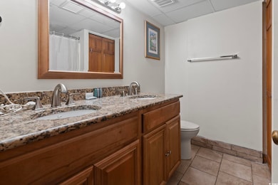 Bathroom with tile patterned floors, vanity, and t