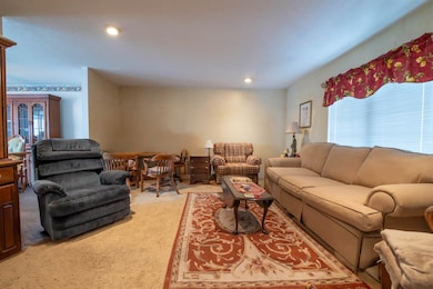 Living room with light carpet and recessed lightin
