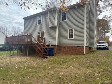 Rear view of house with a yard and a wooden deck