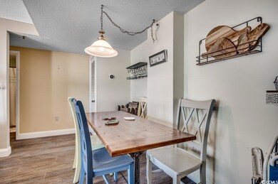 Dining area with wood-type flooring and a textured