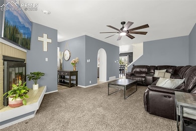 Carpeted living room with a tile fireplace, visibl